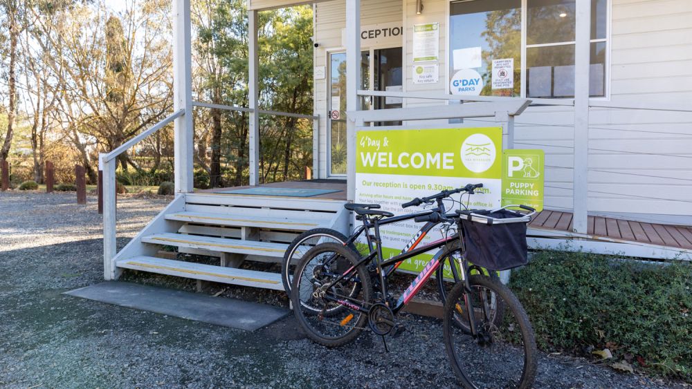 The Yea Riverside Caravan Park front office with two push bikes leaning up against the Welcome sign