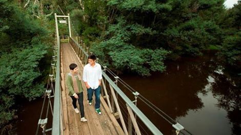 Two people walking over a bridge on the Yea Wetlands Walk